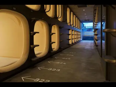 a train aisle with the doors open with writing on the floor at 9h nine hours Suidobashi in Tokyo