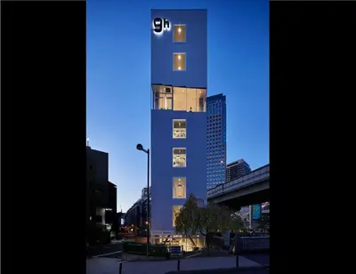a tall blue building with the letter c on it at 9h nine hours Suidobashi in Tokyo