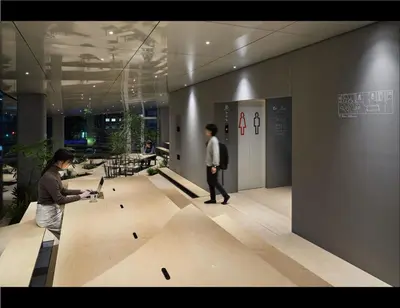 two people walking in a building with a skate park at 9h nine hours Suidobashi in Tokyo