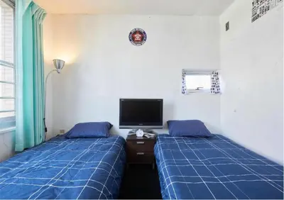 a bedroom with two beds and a tv on the wall at 2BR 5beds Shibuya Shinjuku Harajuku 10min wifi in Tokyo