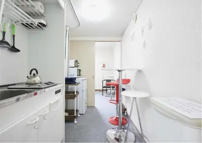 a kitchen with white cabinets and red stools at 2BR 4beds Shibuya Shinjuku Harajuku 10min wifi in Tokyo
