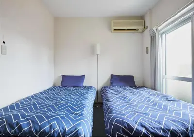 two beds sitting next to a window in a room at 2BR 4beds Shibuya Shinjuku Harajuku 10min wifi in Tokyo