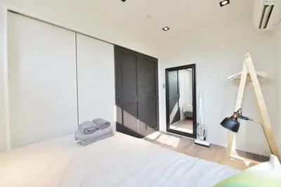 a bedroom with a bed with a mirror and a lamp at Real Life Meguro River in Tokyo