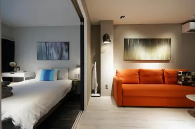 a bedroom with a bed and an orange couch at Real Life Meguro River in Tokyo