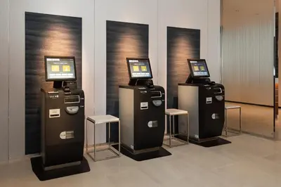 three atm machines with screens on them in a room at Shizutetsu Hotel Prezio Tokyo Tamachi in Tokyo