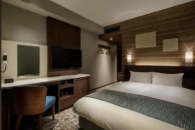 a bedroom with a bed and a flat screen tv at Shizutetsu Hotel Prezio Tokyo Tamachi in Tokyo