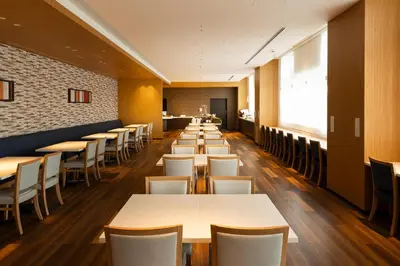 a row of tables and chairs in a restaurant at Shizutetsu Hotel Prezio Tokyo Tamachi in Tokyo