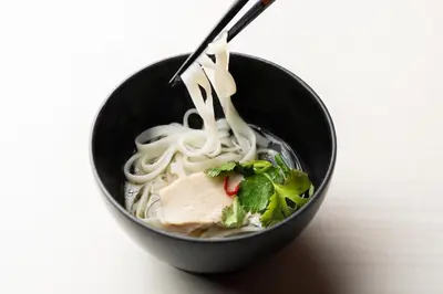 a bowl of soup with noodles and meat in it at Shizutetsu Hotel Prezio Tokyo Tamachi in Tokyo