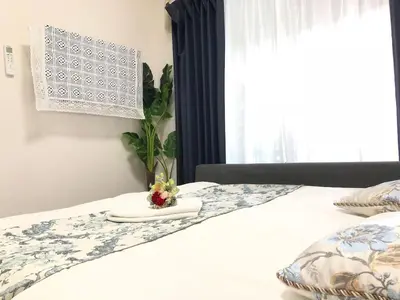 a white bed with a tray with flowers on it at Julian home Shinagawa 5 mins Shibuya 7 mins in Tokyo