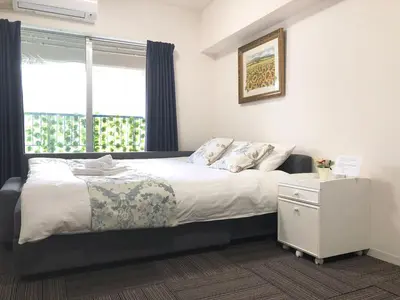 a bedroom with a bed and a window at Julian home Shinagawa 5 mins Shibuya 7 mins in Tokyo