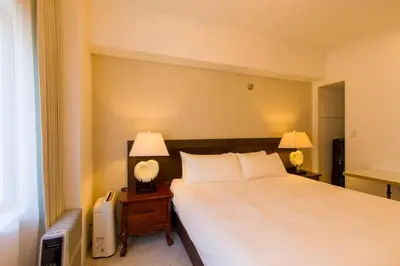 a bedroom with a bed and two lamps on a night stand at Himalaya Cloud Hotel in Tokyo