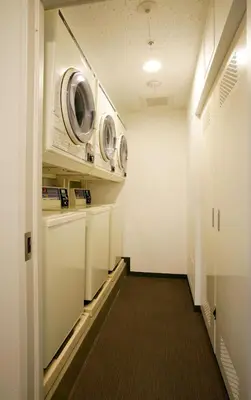 a hallway with two washer and dryers in a room at Hotel Lumiere Nishikasai in Tokyo