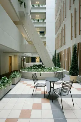 a courtyard with a table and chairs in a building at Hotel Lumiere Nishikasai in Tokyo