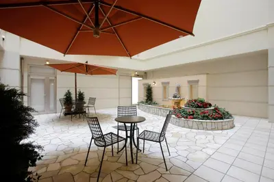 a patio with a table and chairs and a fountain at Hotel Lumiere Kasai in Tokyo
