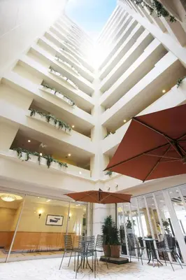 a lobby with tables and chairs and umbrellas at Hotel Lumiere Kasai in Tokyo