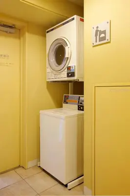 a laundry room with a washing machine and a washer at Hotel Lumiere Kasai in Tokyo