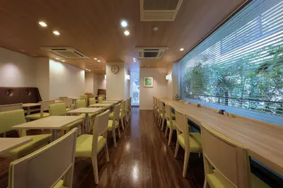 a restaurant with tables and chairs and a large window at Keio Presso Inn Gotanda in Tokyo