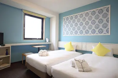 a hotel room with two beds and a window at HOTEL EURASIA MAIHAMA ANNEX in Urayasu