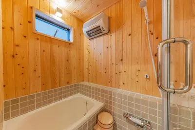 a bathroom with a tub and a window and wooden walls at Yadoya Asakusa Sennosato / Vacation STAY 46671 in Tokyo