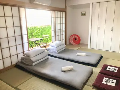 a room with three beds in a room with a window at ohayo\u672c\u6240 in Tokyo