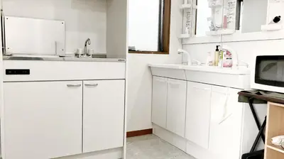 a white kitchen with white cabinets and a sink at ohayo\u672c\u6240 in Tokyo
