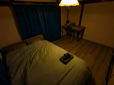 a bedroom with a bed and a desk and a table with a chair at SquareHouse Nishiarai in Tokyo