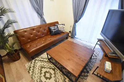 a living room with a leather couch and a coffee table at TOMARIE Residential Suite Edogawa in Tokyo