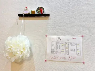 a sign on a wall next to a table with a flower at Upper Hotel Ryogoku in Tokyo