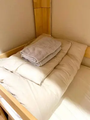 a bed with white sheets and towels on it at Upper Hotel Ryogoku in Tokyo