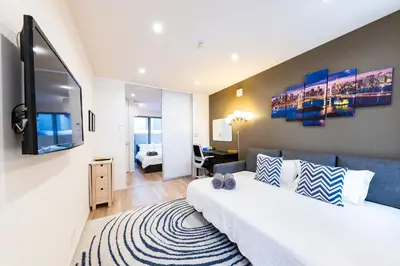a bedroom with a large bed and a living room at Ueno Garden House - 2 mins walk to subway, 2 mins train to Akihabara, 2 mins train to Asakusa in Tokyo