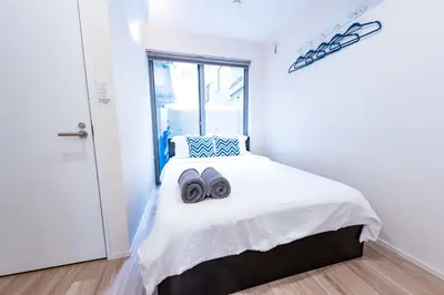 a bedroom with a bed with two towels on it at Ueno Garden House - 2 mins walk to subway, 2 mins train to Akihabara, 2 mins train to Asakusa in Tokyo