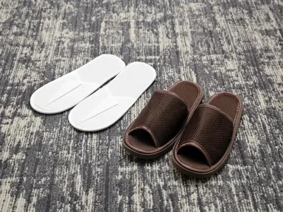 two brown and white sandals sitting on a floor at Keio Presso Inn Kanda in Tokyo