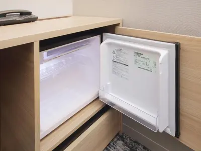 an open refrigerator with its door open in a kitchen at Keio Presso Inn Kanda in Tokyo