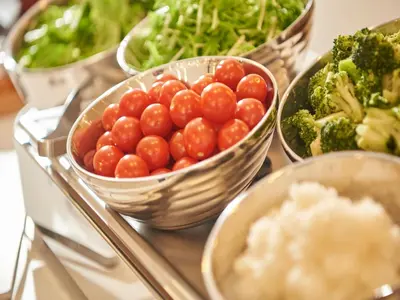 a group of bowls of tomatoes and broccoli on a table at Keio Presso Inn Kanda in Tokyo