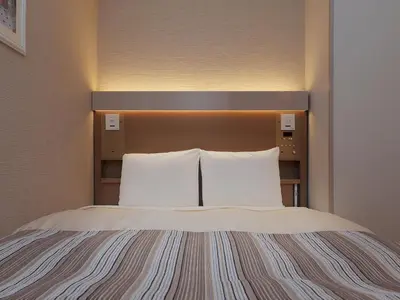 a bed in a hotel room with two white pillows at Keio Presso Inn Otemachi in Tokyo
