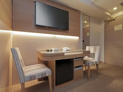 a room with a desk and a tv on a wall at Keio Presso Inn Otemachi in Tokyo