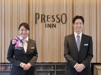 two people in suits standing in front of a presso inn at Keio Presso Inn Otemachi in Tokyo