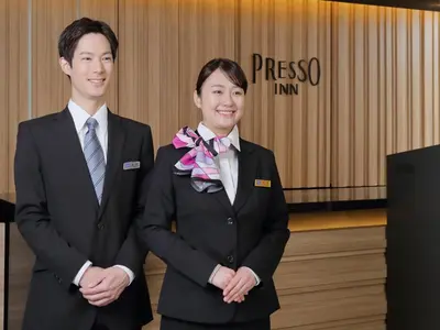two people in suits standing next to each other at Keio Presso Inn Otemachi in Tokyo