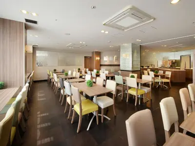a restaurant with wooden tables and yellow chairs at Keio Presso Inn Otemachi in Tokyo