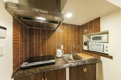 a kitchen with a sink and a stove at YADOYA Sennokawa in Tokyo