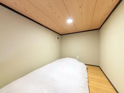 a bed in a room with a wooden ceiling at YADOYA Sennokawa in Tokyo