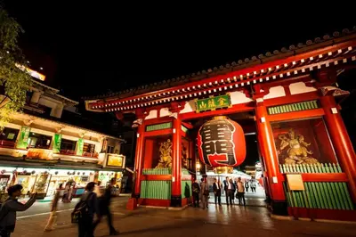 a group of people standing outside a building at night at YADOYA Asakusa-Honkan in Tokyo