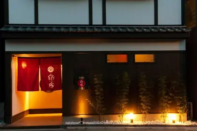 a building with a red door with plants and lights at YADOYA Asakusa-Honkan in Tokyo