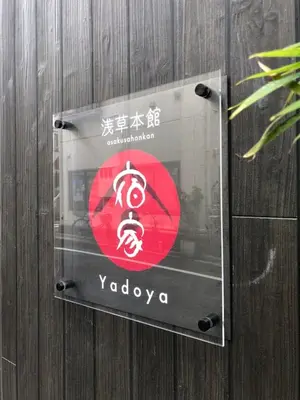 a sign on a wooden wall with a sign for yodaarma at YADOYA Asakusa-Honkan in Tokyo
