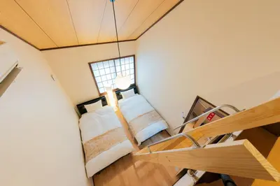 two beds in a room with a window at YADOYA Hakuteian in Tokyo