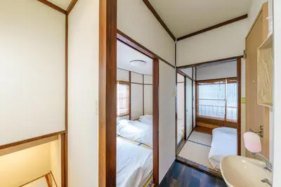 a room with two beds and a sink and a mirror at YADOYA Chigusacho in Tokyo