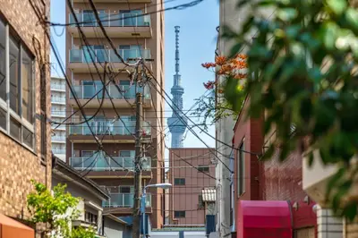 a city street with the television tower in the background at YADOYA Chigusacho in Tokyo