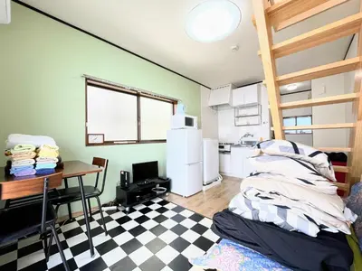 a room with a kitchen with a table and a refrigerator at House Kadoi201 in Tokyo