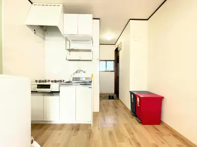 a kitchen with white cabinets and a red trash can at House Kadoi201 in Tokyo