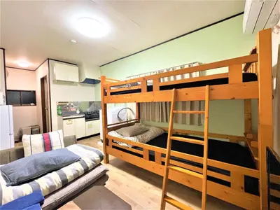 a room with two bunk beds and a kitchen at House Kadoi202 in Tokyo
